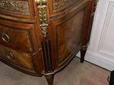 a wooden cabinet with a marble top in the corner of a room