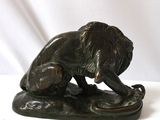 bronze statue of a lion on a rock on a white background