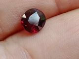un gros plan sur la main d'une personne tenant un diamant rouge et blanc