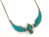 collier avec des ailes en turquoise et une perle verte, monté sur une chaîne en argent