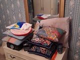a dresser with a mirror and a pile of clothes on it
