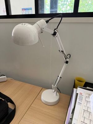 un bureau sur lequel se trouvent une lampe et un téléphone