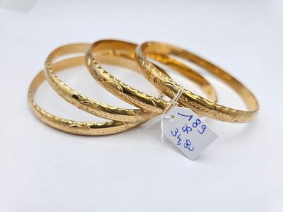 three gold rings with a price tag on them sitting on a table