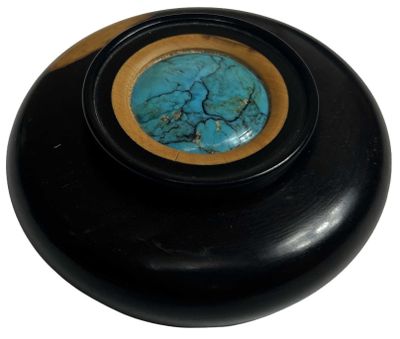 un bol noir avec une pierre bleue au centre