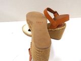 pair of women ' s wedged sandals sitting on top of a white table