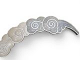 a close up of a brooch with spiral designs on it