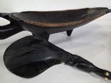 an image of a black and gold bowl and spoon on a white surface