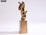 statue représentant deux mains qui se tiennent l'une l'autre, posée sur un socle en marbre