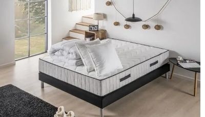 un lit sur lequel est posé un matelas dans une pièce