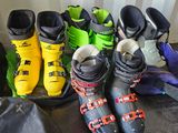 many pairs of ski boots lined up on the floor