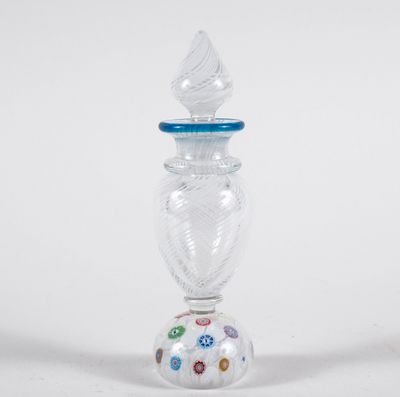 a glass vase with a blue top on a white surface
