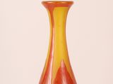a red and yellow vase sitting on a table