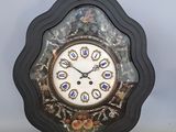 une horloge posée sur une table devant un mur