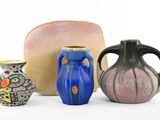 trois vases posés l'un à côté de l'autre sur une surface blanche