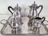 a silver tray with a silver tea set on it
