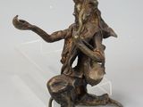 statue of a woman sitting on a rock with a bird in her hand