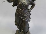 statue en bronze représentant une femme tenant un bouquet de fleurs, posée sur un socle