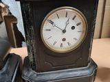 a black clock sitting on a table next to a black clock