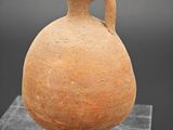 une image représentant un vase en argile posé sur un socle en marbre