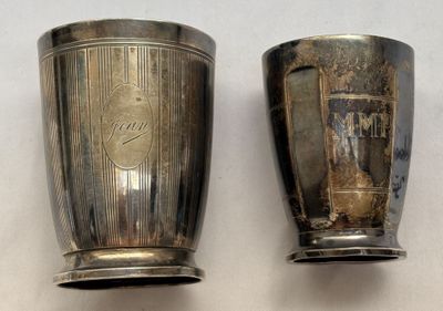 deux tasses en argent posées l'une à côté de l'autre sur une table