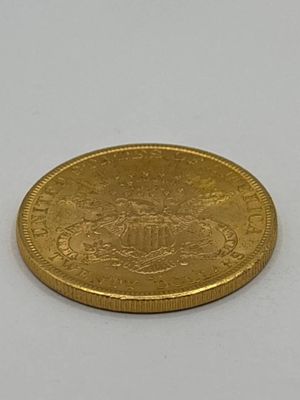 gros plan d'une pièce d'or sur une surface blanche