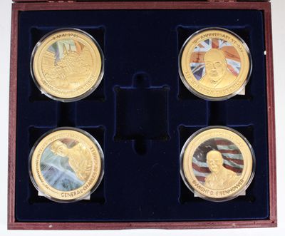 trois pièces d'or dans une boîte en bois ornée d'un drapeau et d'une médaille