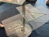 a glass table with two glass shelves on top of it