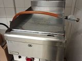 un plan de travail en acier inoxydable équipé d'une plaque de cuisson, dans une cuisine