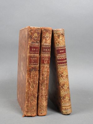 two old books sitting on top of each other on a gray surface