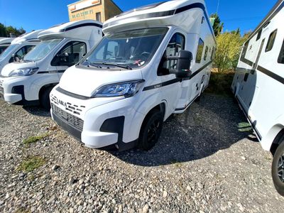 plusieurs camping-cars blancs garés en rangée sur un parking