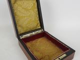 a small wooden box with a lid on a white surface