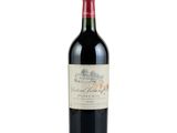 the bottle of red wine is sitting on a white surface