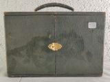 a green suitcase sitting on top of a white table