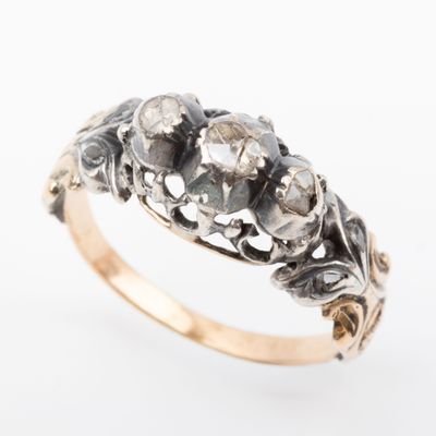 a close up of a gold and diamond ring on a white background