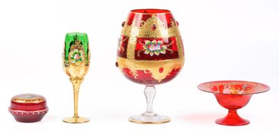 trois verres à vin et une coupe à vin posés sur une surface blanche