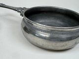 a silver bowl with a spoon in it on a table
