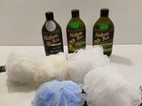 trois bouteilles de shampoing, une boule de savon et une éponge posées sur un plan de travail
