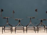 three chairs sitting on top of each other in front of a blue wall