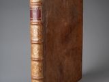 un vieux livre à la couverture brune posé sur une table