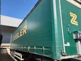 a large green truck that is parked in front of a building