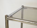 a metal shelf with a glass top on a white wall