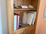 a wooden bookcase with books on it in the corner of a room