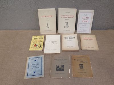 several books are sitting on a table in front of a gray wall