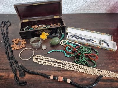a wooden box with a bunch of jewelry on it