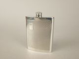a silver flask with a metal cap on a table