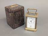 une petite horloge en métal posée à côté d'une petite boîte en bois