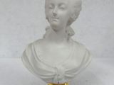 a white bust of a woman with a black base on a white background