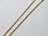 a close up of a gold chain on a white surface
