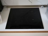 a stove top with a black burner on it in a kitchen