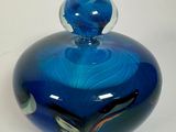 un bocal en verre bleu orné d'un motif bleu en spirale